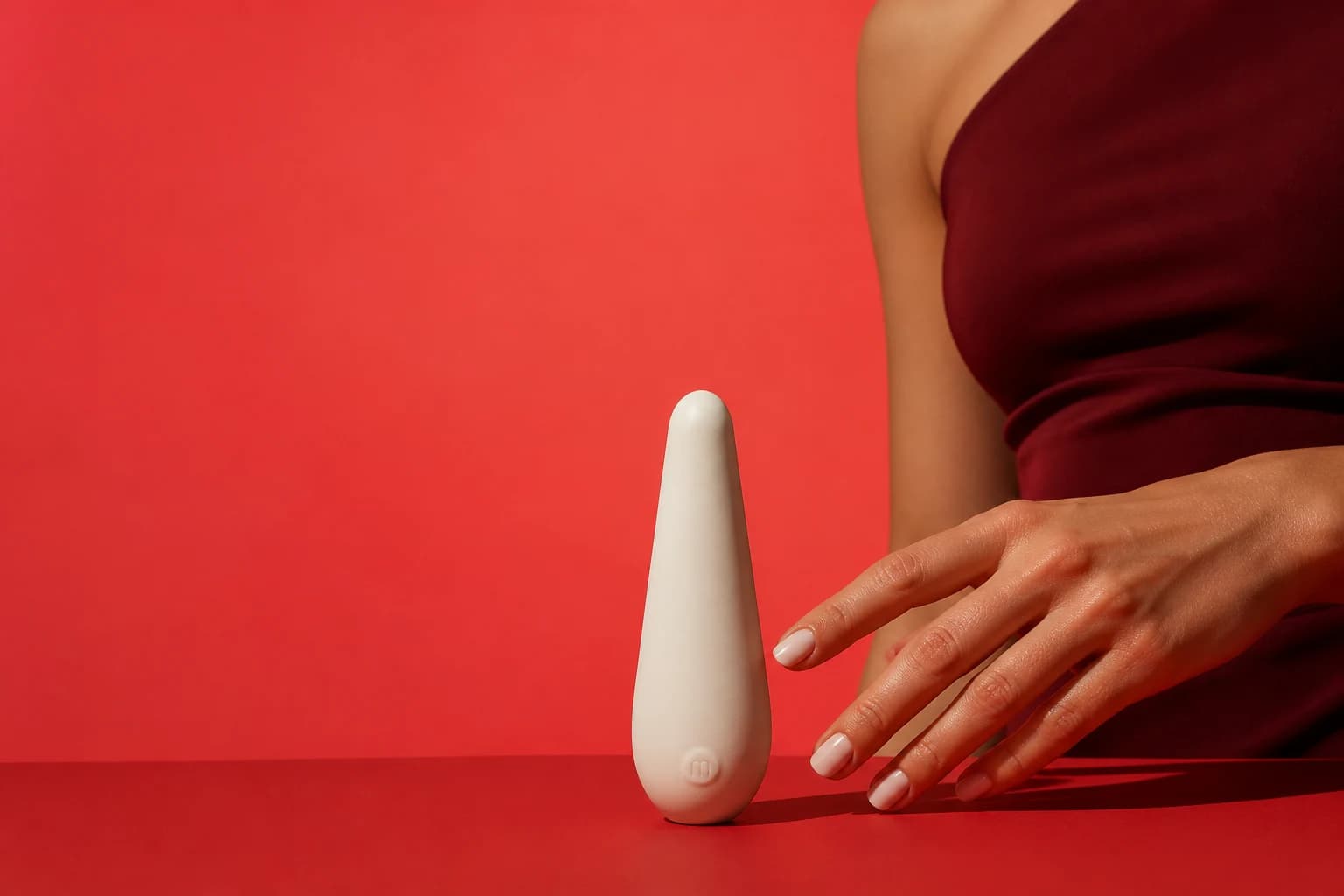 Ivory wellness device in a coral studio with a model's hand